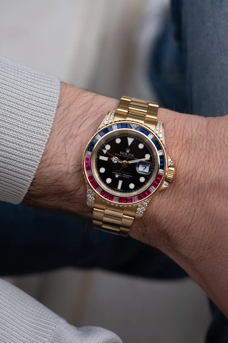 Orologio in oro con lunetta di rubini e zaffiri indossato