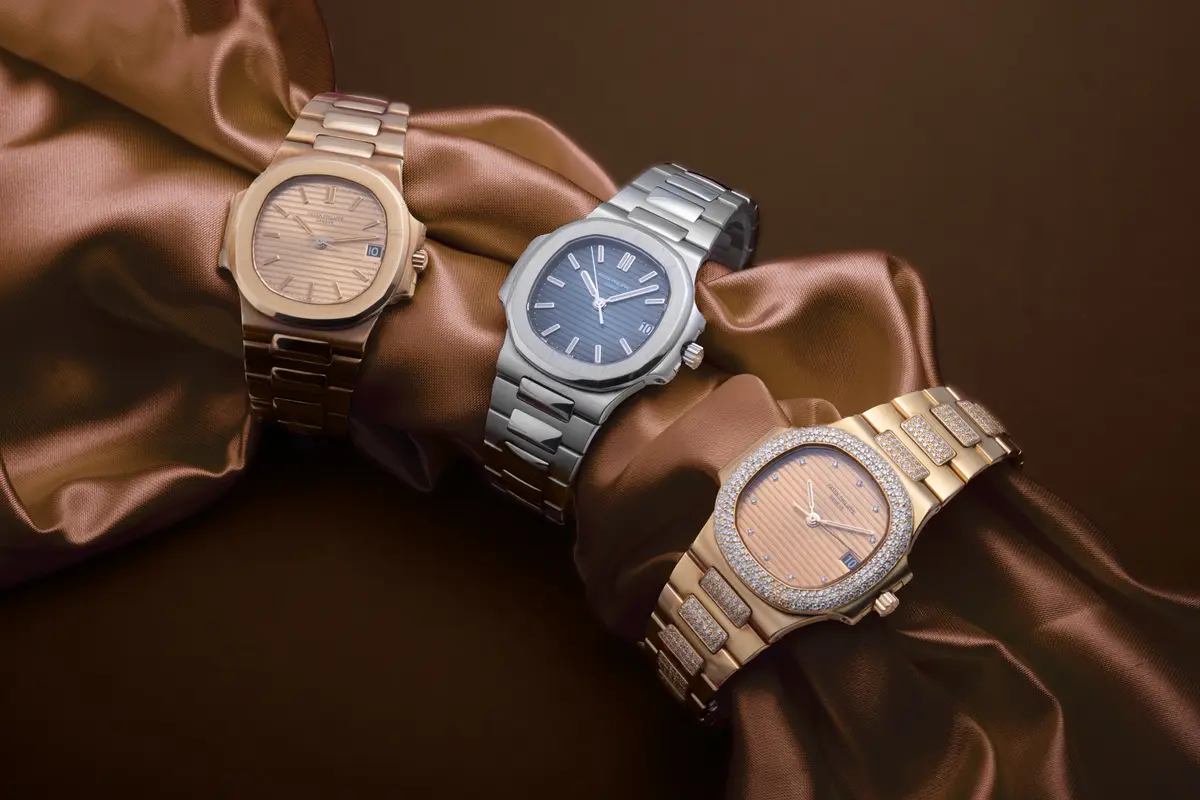 Tre orologi su un drappo di seta color bronzo
