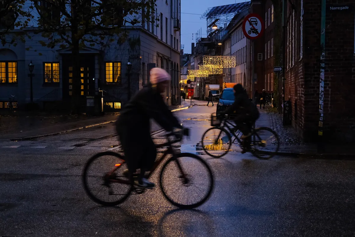 Ciclisti su una strada bagnata all'imbrunire